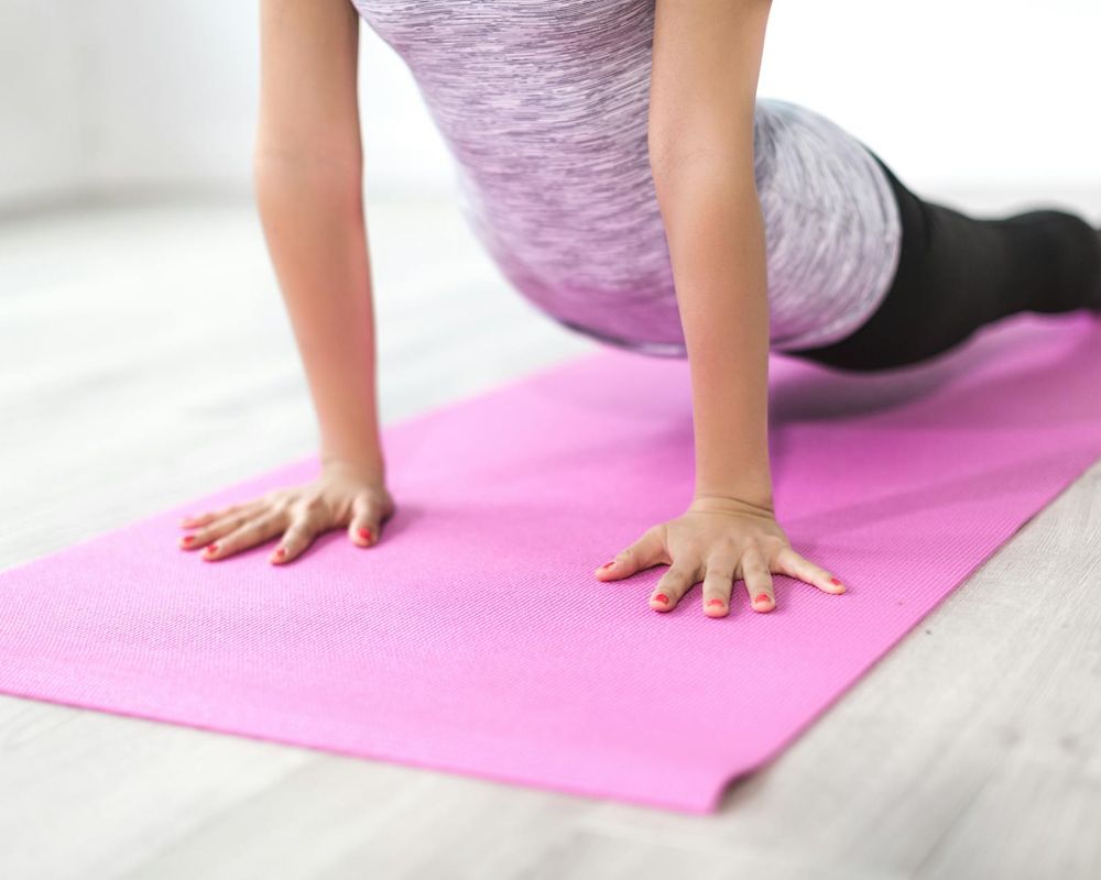 Close up of hands during a yoga stretch exercise on mat