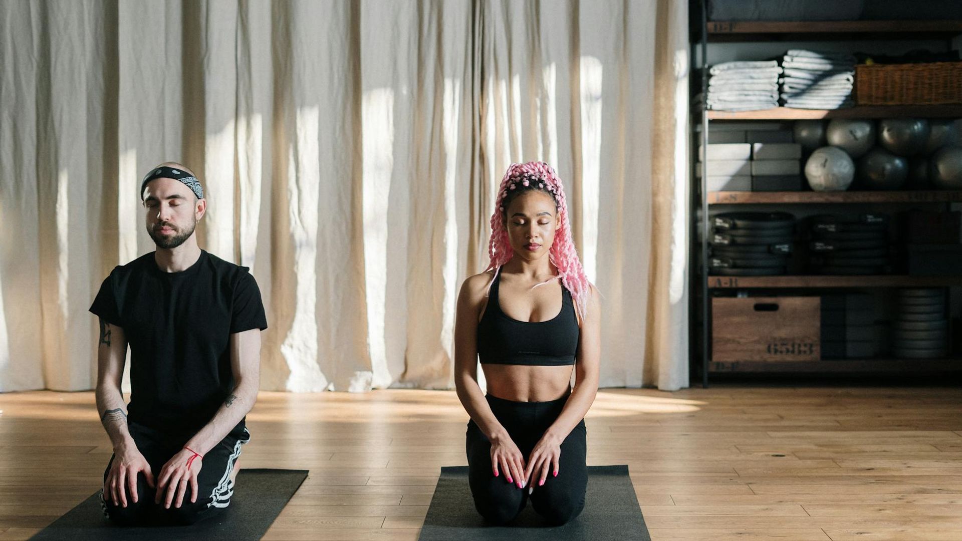 Person practicing yoga in a dark studio with blue lighting focus on silhouette